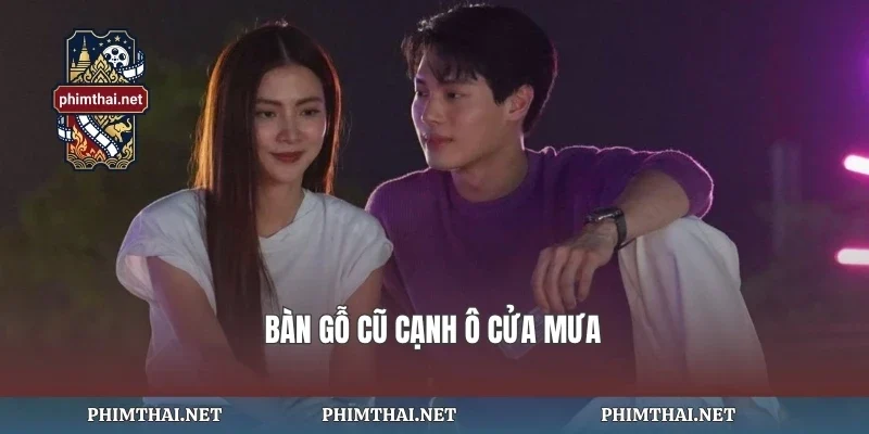 Bàn gỗ cũ cạnh ô cửa mưa