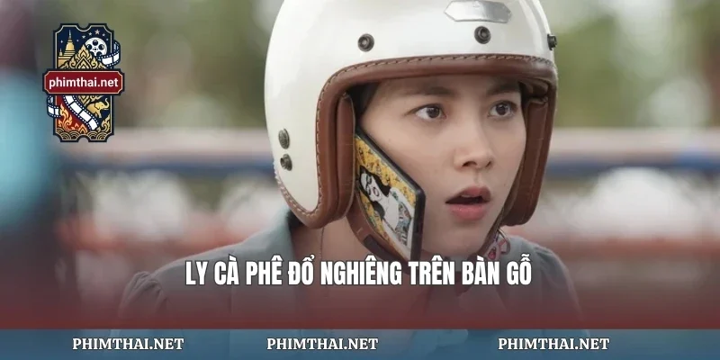 Ly cà phê đổ nghiêng trên bàn gỗ